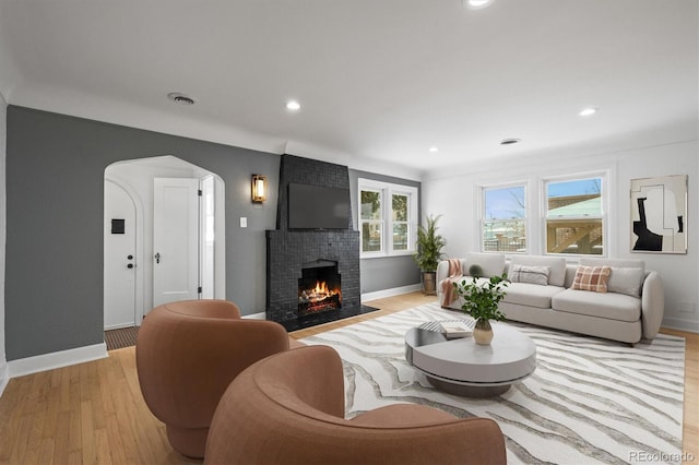 living room with a fireplace and light hardwood / wood-style flooring