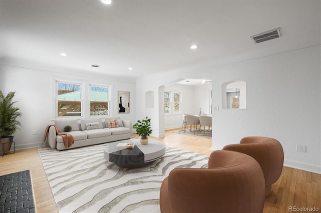 living room featuring light hardwood / wood-style flooring and crown molding