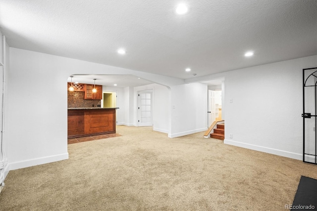 interior space featuring light carpet and a textured ceiling