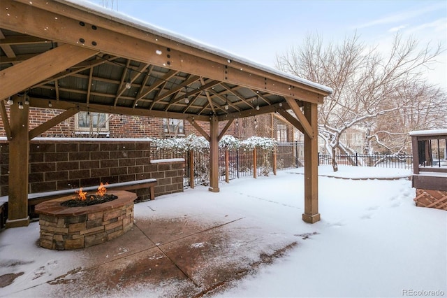 snow covered patio with a fire pit