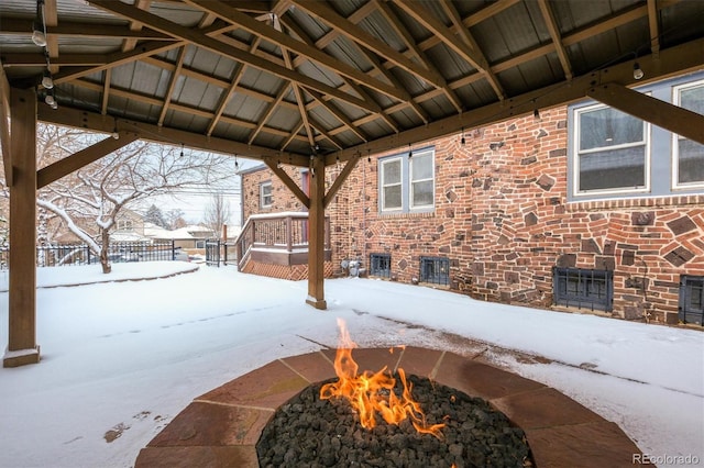 snow covered patio with a gazebo and an outdoor fire pit