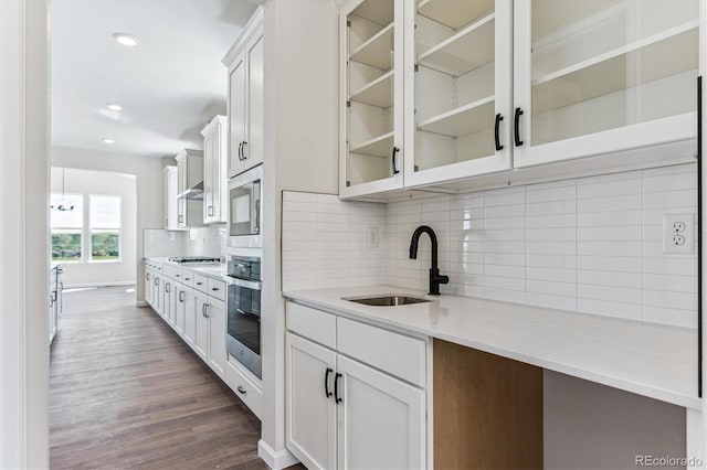 4728 Twelve Oaks Way, Castle Rock, CO 80104 - kitchen featuring appliances with stainless steel finishes, a sink, glass insert cabinets, dark wood-style floors, and tasteful backsplash