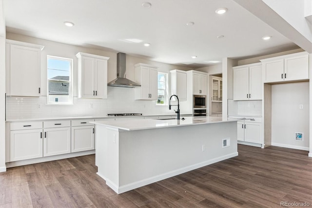 4728 Twelve Oaks Way, Castle Rock, CO 80104 - kitchen featuring wall chimney range hood, a sink, stainless steel appliances, an island with sink, and white cabinetry