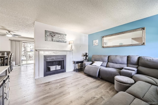 11636 Community Center Dr Unit 29, Northglenn, CO 80233 - living room featuring a fireplace with flush hearth, wood finished floors, a textured ceiling, and ceiling fan