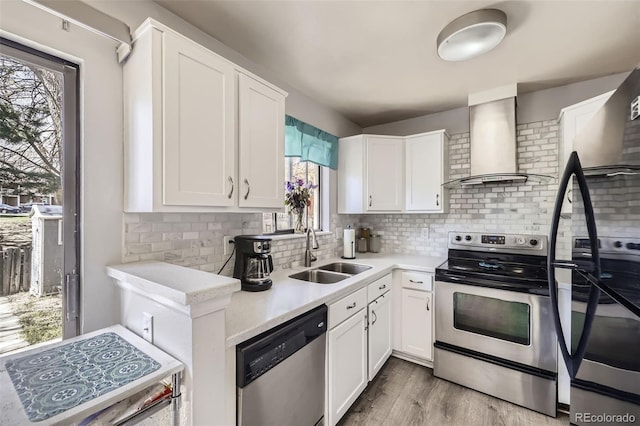 11636 Community Center Dr Unit 29, Northglenn, CO 80233 - kitchen featuring stainless steel appliances, wall chimney exhaust hood, light countertops, white cabinetry, and decorative backsplash