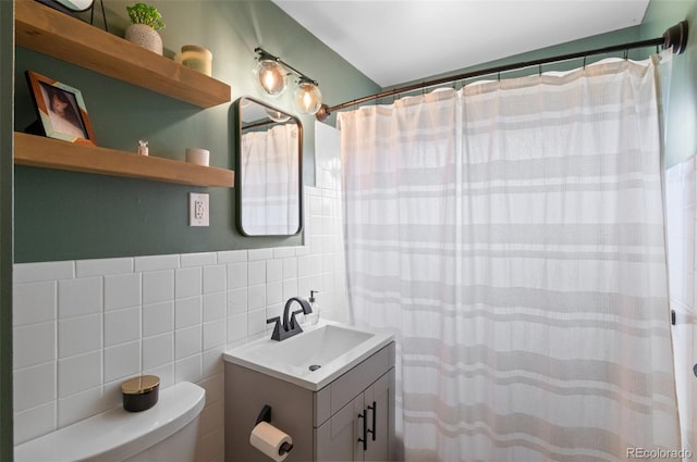 full bathroom featuring toilet, curtained shower, vanity, and tile walls