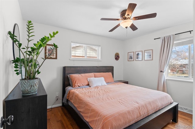 bedroom with a ceiling fan, baseboards, and wood finished floors