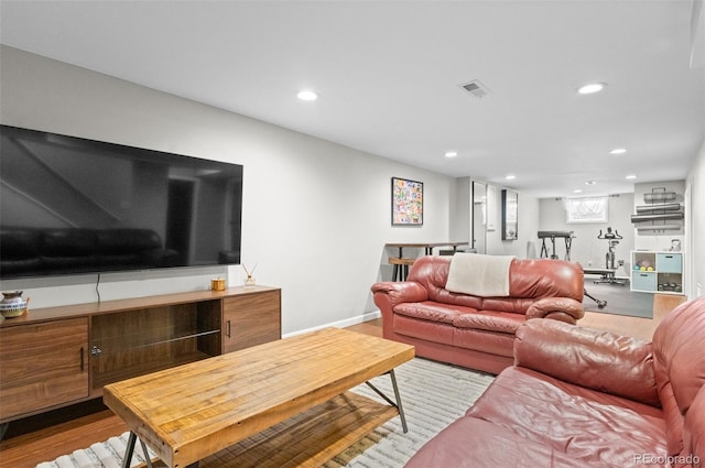 living room with baseboards, wood finished floors, visible vents, and recessed lighting