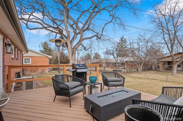 wooden terrace featuring a yard, an outdoor fire pit, grilling area, and fence