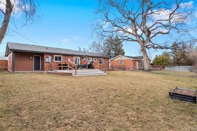 rear view of property featuring a yard, a fenced backyard, and brick siding