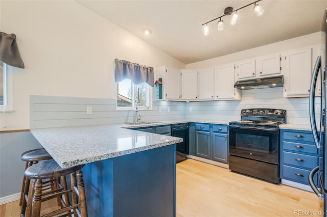 kitchen featuring blue cabinetry, white cabinetry, black electric range oven, and light hardwood / wood-style floors