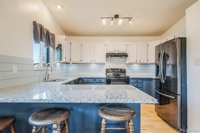 kitchen featuring sink, black electric range, stainless steel refrigerator with ice dispenser, kitchen peninsula, and white cabinets