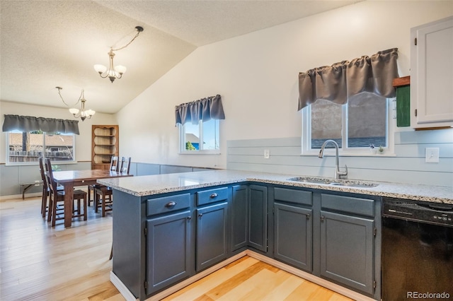 kitchen with kitchen peninsula, sink, dishwasher, a chandelier, and lofted ceiling