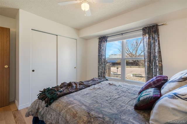 bedroom featuring a closet, ceiling fan, hardwood / wood-style floors, and a textured ceiling