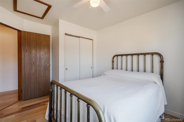 bedroom with light wood-type flooring, a closet, and ceiling fan