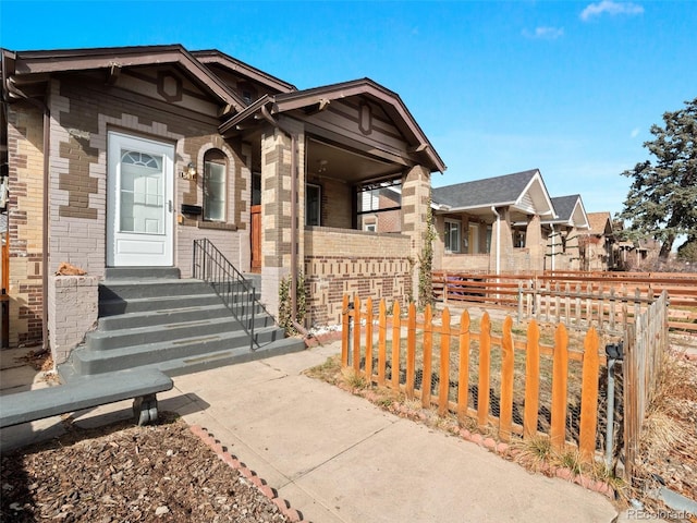 view of front facade with brick siding and fence