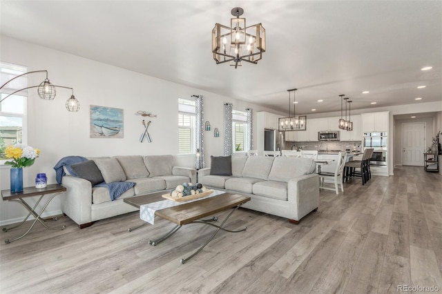 12513 Shore Point St, Firestone, CO 80504 - living room featuring a chandelier, light wood-style flooring, recessed lighting, and baseboards