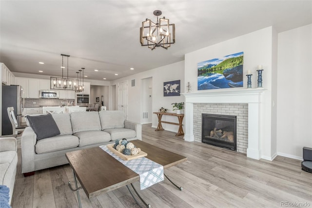 12513 Shore Point St, Firestone, CO 80504 - living room featuring a chandelier, light wood-style floors, recessed lighting, and baseboards