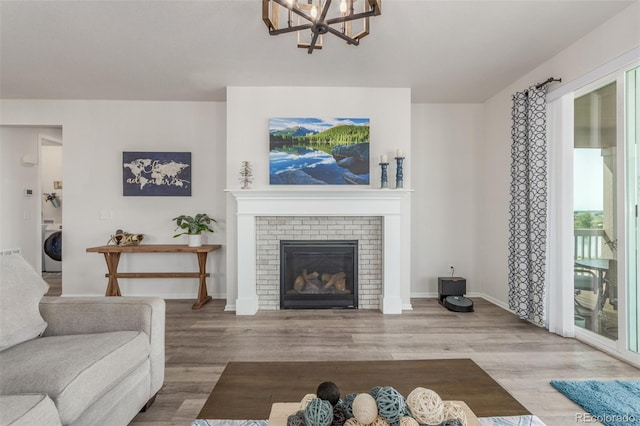 12513 Shore Point St, Firestone, CO 80504 - living room featuring washer / clothes dryer, a chandelier, wood finished floors, and baseboards