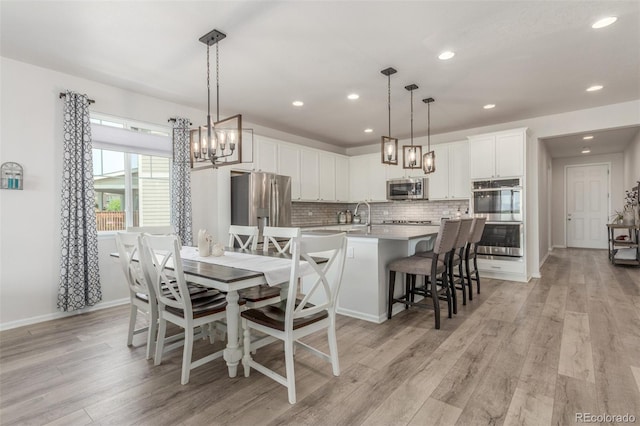 12513 Shore Point St, Firestone, CO 80504 - dining room with a chandelier, light wood finished floors, recessed lighting, and baseboards