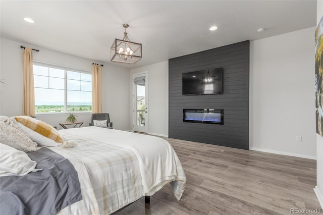 12513 Shore Point St, Firestone, CO 80504 - bedroom featuring a chandelier, wood finished floors, a fireplace, baseboards, and recessed lighting