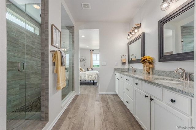 12513 Shore Point St, Firestone, CO 80504 - bathroom with double vanity, wood finished floors, a shower stall, baseboards, and ensuite bathroom