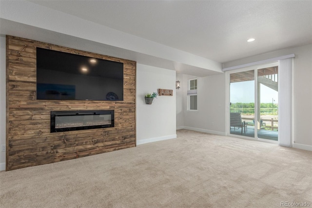 12513 Shore Point St, Firestone, CO 80504 - unfurnished living room featuring carpet flooring, a glass covered fireplace, baseboards, and recessed lighting