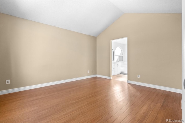 spare room with lofted ceiling and light hardwood / wood-style flooring