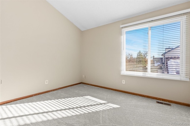 spare room featuring vaulted ceiling and carpet floors