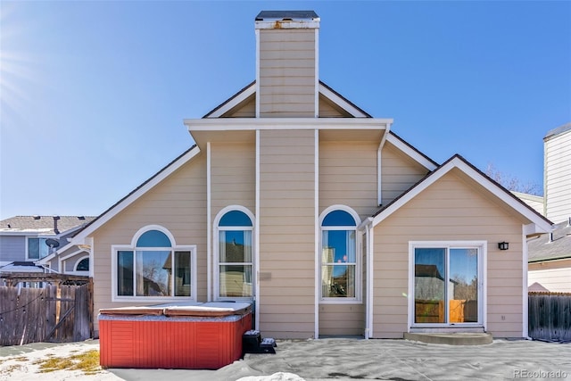 back of property featuring a hot tub