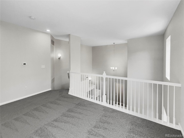 empty room featuring an inviting chandelier and carpet flooring