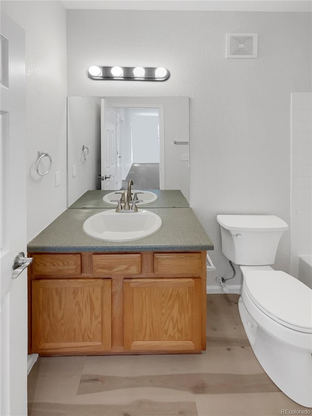 bathroom featuring vanity, wood-type flooring, and toilet