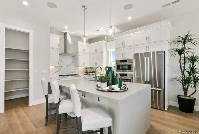 1736 Barefoot Dr, Windsor, CO 80550 - kitchen with wall chimney exhaust hood, freestanding refrigerator, white cabinetry, and recessed lighting
