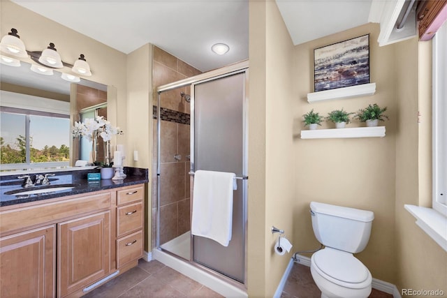 bathroom featuring vanity, a shower with shower door, toilet, and tile patterned flooring