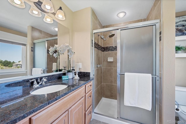 bathroom featuring a shower with door, vanity, and toilet