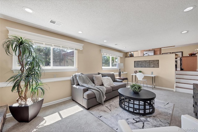 living room featuring a textured ceiling and light colored carpet