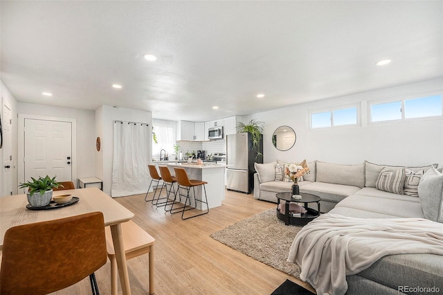 living room with recessed lighting and light wood-style floors