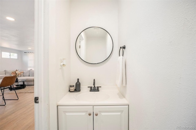 bathroom featuring vanity, recessed lighting, and wood finished floors