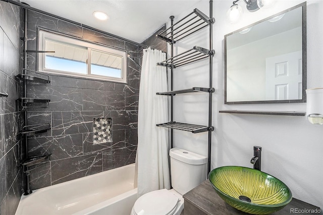 full bath with a sink, toilet, and shower / tub combo with curtain