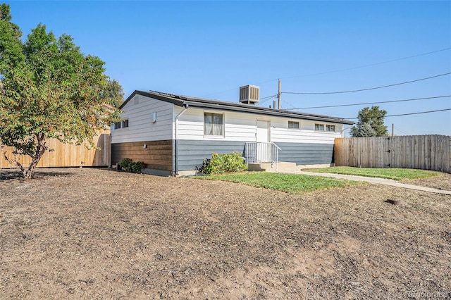 back of property featuring central AC and fence