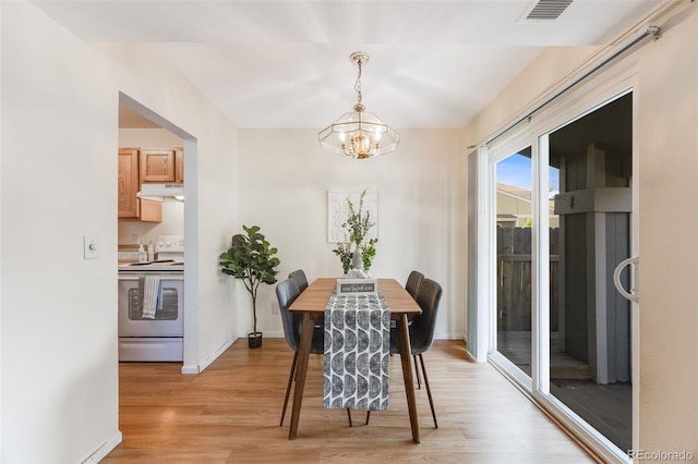 dining room featuring light hardwood / wood-style flooring and an inviting chandelier