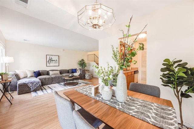 dining area featuring a notable chandelier and light wood-type flooring