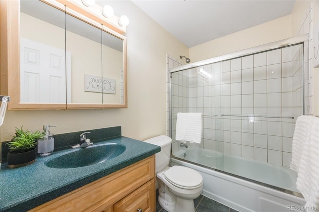 full bathroom featuring vanity, bath / shower combo with glass door, toilet, and tile patterned floors