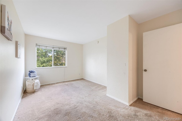 unfurnished room featuring light carpet