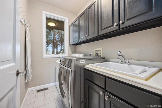 laundry room with separate washer and dryer, cabinet space, baseboards, and light tile patterned flooring
