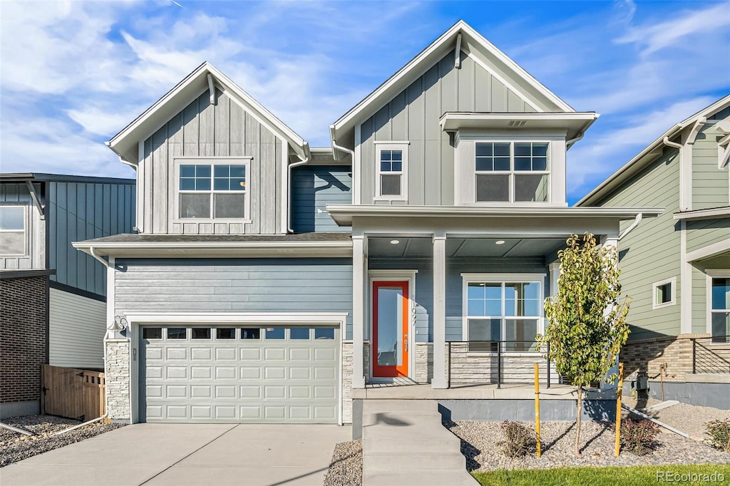 21097 E 62nd Dr, Aurora, CO 80019 - view of front of property with an attached garage, covered porch, board and batten siding, and concrete driveway