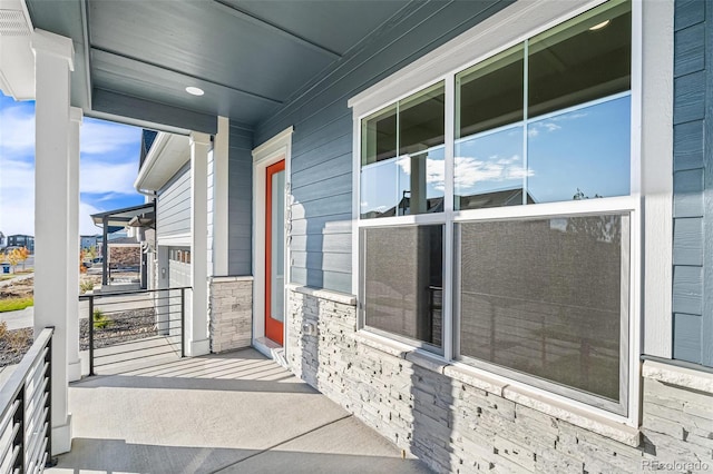 doorway to property with stone siding and a porch