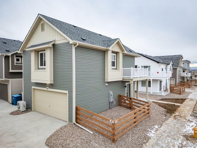 46538 Avery Ln, Bennett, CO 80022 - view of side of property featuring a shingled roof, concrete driveway, a garage, board and batten siding, and a balcony