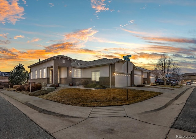 view of front of house with a garage, concrete driveway, and brick siding