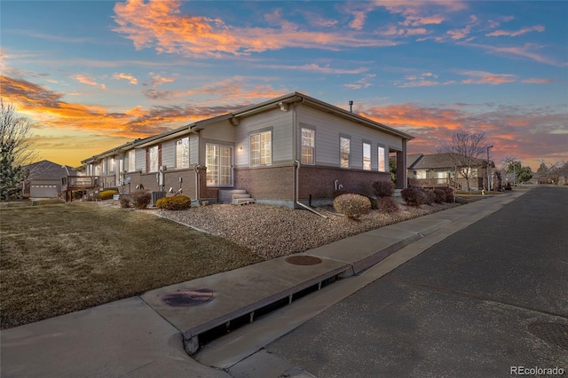 view of home's exterior featuring entry steps, cooling unit, and brick siding